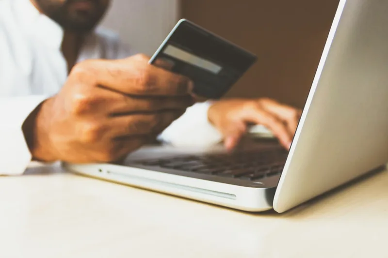 Modern ecommerce experience — woman browsing on laptop in bright UAE apartment, online shopping
